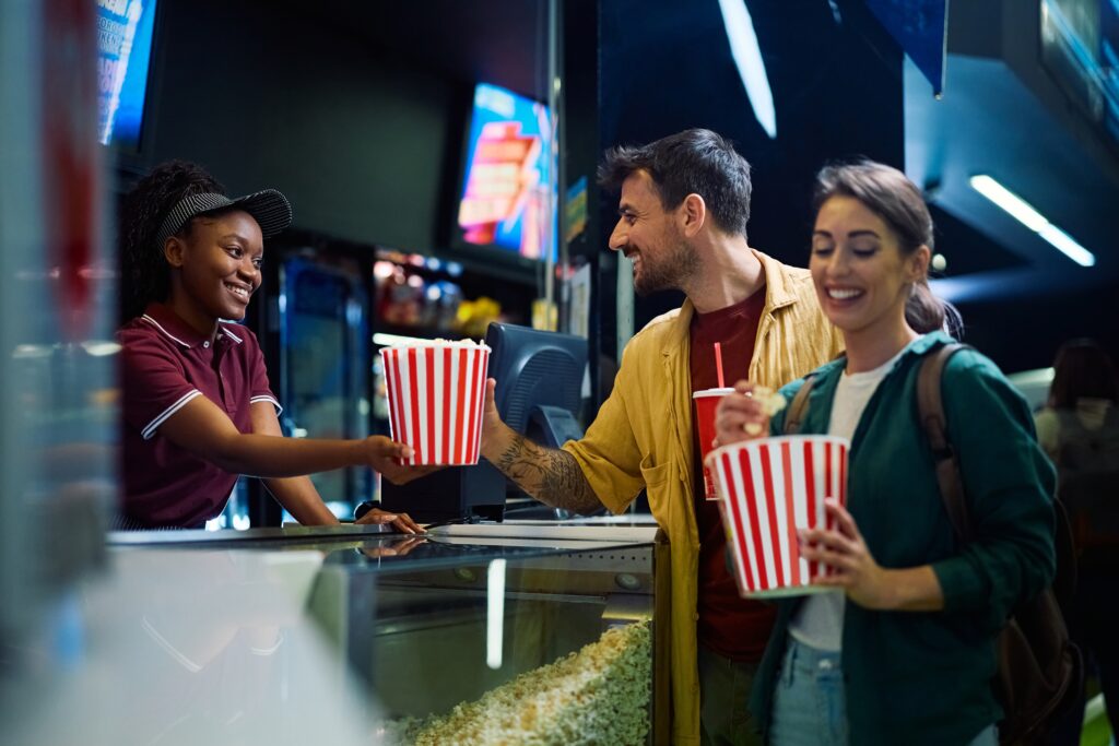 Happy,Man,Buying,Popcorn,And,Drinks,From,Cahier,While,Being